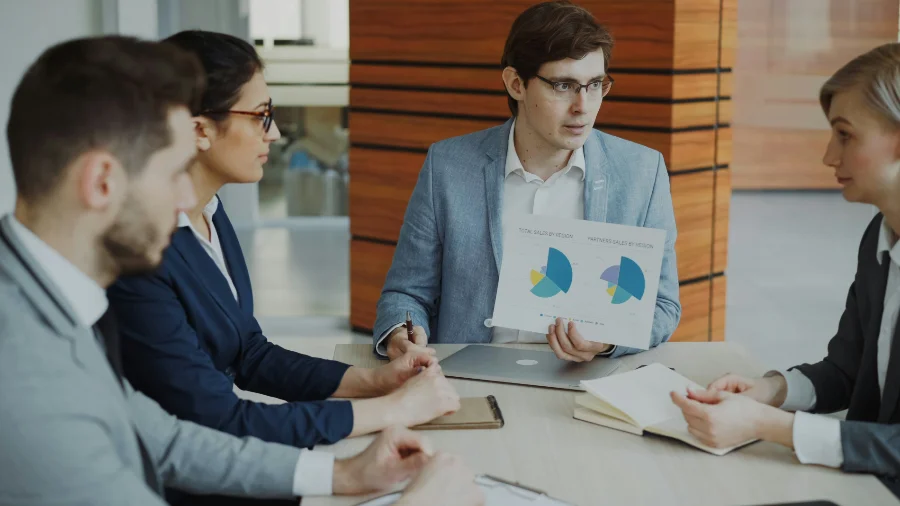 Meeting-Situation mit Person, die Diagramm hochhält